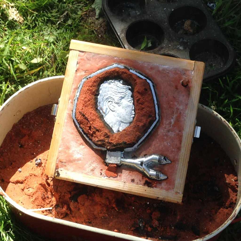 Aluminium coin in casting sand